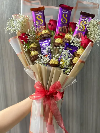You can never go wrong with chocolates and flowers. This is our deluxe chocolate bouquet, featuring a mix of Dairy Milk and Ferrero Rocher chocolates nestled among fresh red roses and baby's breath.