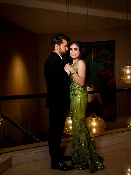 A sophisticated couple portrait taken on a mezzanine, with warm ambient lighting creating a romantic mood for this engagement shoot.