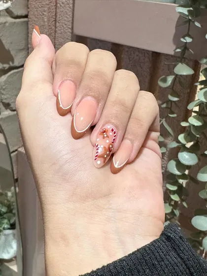 A close-up on the adorable, hand-painted candy cane and gingerbread man accent nail. It's all in the details!
