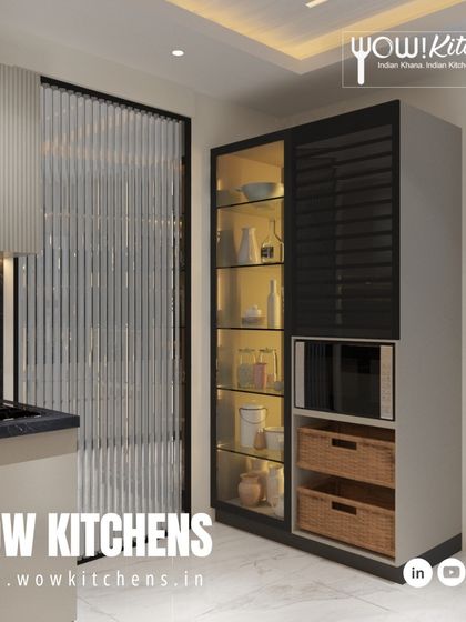 We design beautiful storage solutions. This tall pantry unit features a mix of open glass shelving, closed cabinets, and space for a microwave, combining functionality with modern aesthetics.