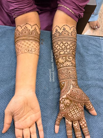 This image shows the contrast between a completed arm and one just beginning, illustrating the process of building a complex bridal design.