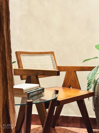 The 'Malben' chair in a quiet corner, paired with a teak and glass side table. This shows how my custom-made pieces can fit perfectly into any space.