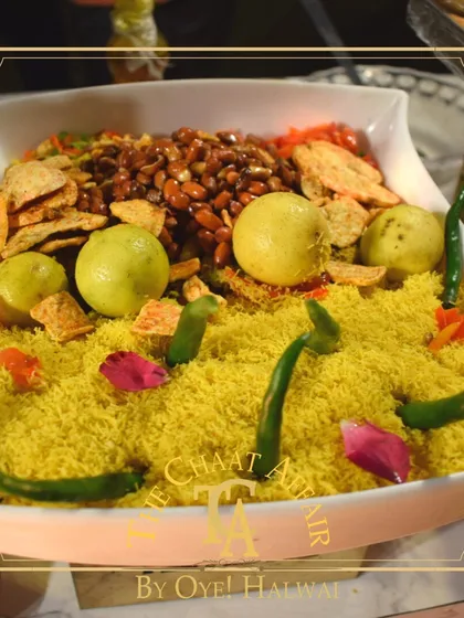Our creative presentation of Bhel Puri. We assemble fresh ingredients like puffed rice, sev, peanuts, and chopped vegetables in an attractive display, ready to be mixed into a delicious and tangy snack for your guests.