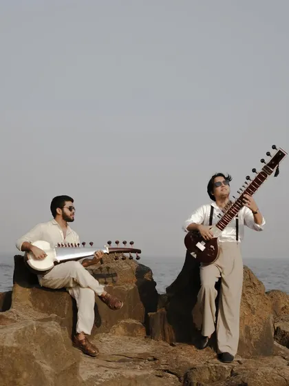 A creative shot from our photoshoot, with both of us and our instruments against the vastness of the sea.