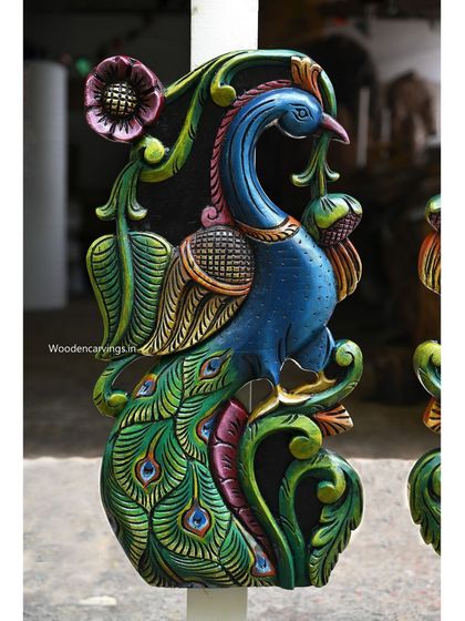 A side view of the colorful peacock wall mount, showing the graceful curve of its neck and the floral motifs.