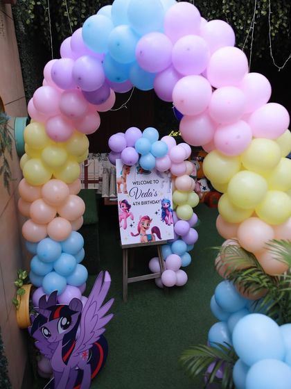 A beautiful rainbow balloon arch creates a magical entrance for the "My Little Pony" themed party.