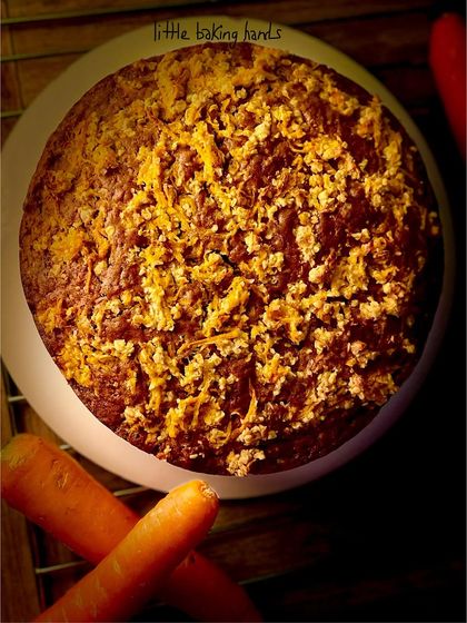 An overhead view of the spiced carrot raisin tea cake, surrounded by the fresh carrots that give it its flavour and moisture.