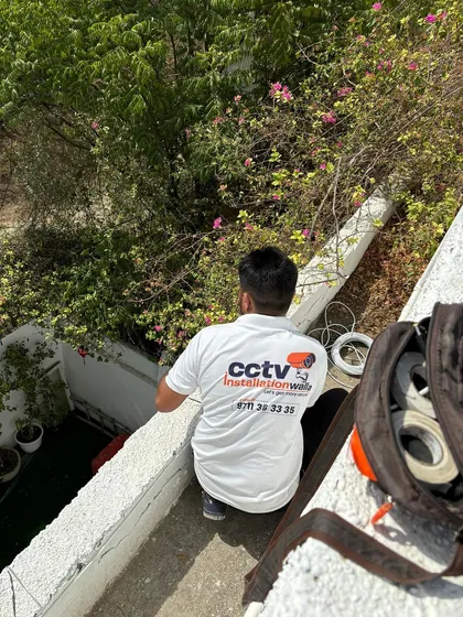 A technician from my team carefully managing the wiring for an outdoor camera. We ensure all connections are secure and weatherproof for reliable performance.
