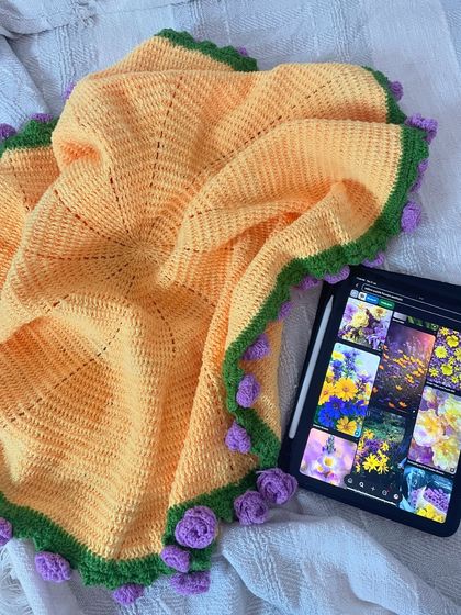 The bouquet blanket, spread open to show its full size. The intricate crochet work and floral border are on full display.