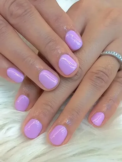 This image showcases a beautiful and clean application of a soft lilac polish on short, natural nails. It's a perfect example of a simple, pretty, and everyday manicure.
