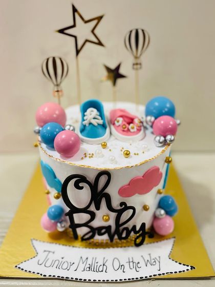 A close-up showing the detail on the fondant baby shoes and cloud decorations.