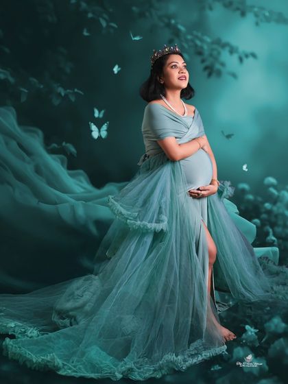 A fairytale moment brought to life. This artistic portrait features the mom-to-be as a queen in an enchanted forest, complete with a crown and magical butterflies.