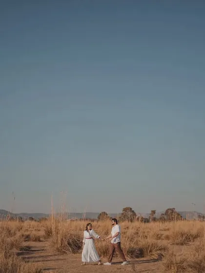 A beautiful wide-angle shot showing the couple in a vast, open landscape under a clear blue sky. This type of image is perfect for creating a sense of freedom and adventure.