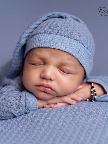 The classic 'chin on hands' pose is a favorite for showing off a newborn's chubby cheeks and peaceful expression. I achieve this pose gently and patiently, always following the baby's lead.