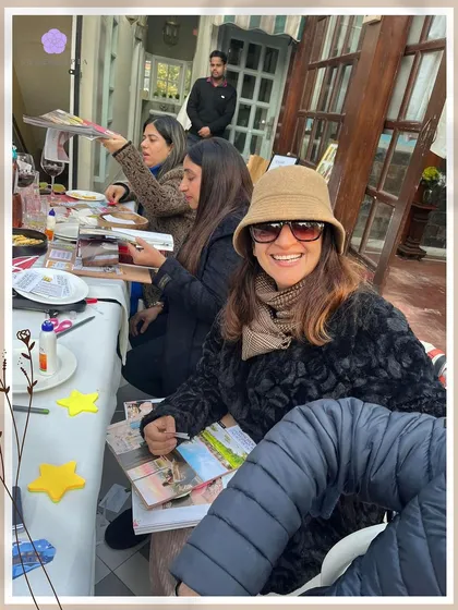 The focus and fun of a vision board workshop. This participant is all smiles as she gets into her creative zone, surrounded by magazines and art supplies.