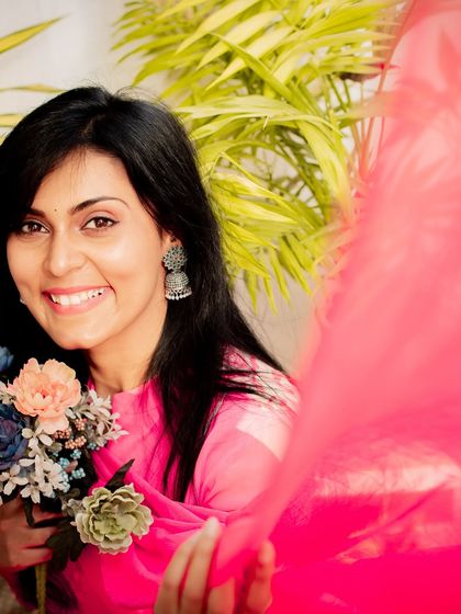 A joyful and dynamic portrait, with a splash of pink fabric adding movement and energy to the shot.