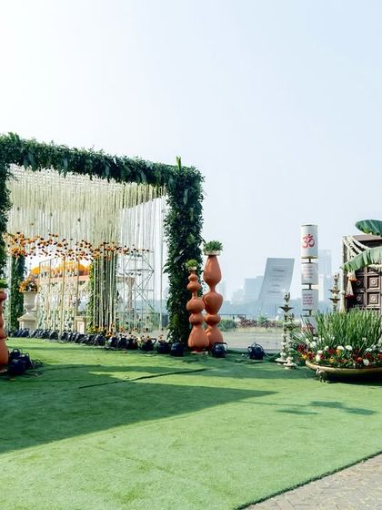 A wider view of the traditional wedding entrance, featuring a grand floral arch, a custom welcome scroll, and sacred elements like banana leaves, all coming together to honor culture and celebration.