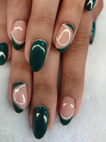 Showcasing our modern and trendy nail art. This design features a deep forest green polish combined with negative space and delicate white line work, creating a chic and sophisticated look on natural nails.