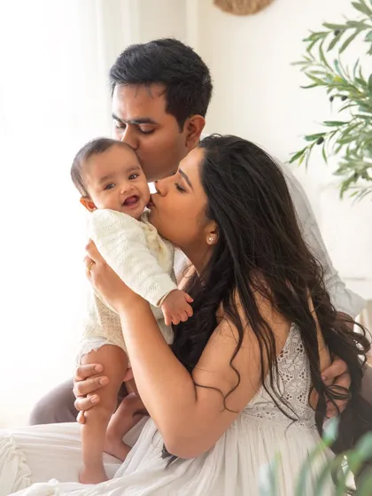 Kisses for a happy baby. This photo is overflowing with love, capturing a beautiful memory for this family during their baby's 6-month photoshoot.