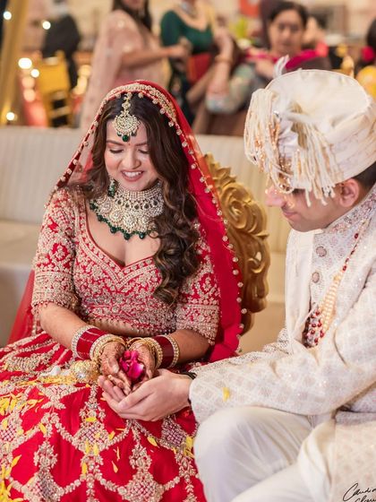 A magical moment between the bride and groom during their wedding ceremony. Her smile says it all, and her makeup looks as fresh as when it was first applied.