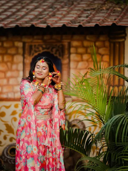 Adjusting her floral earrings, this candid shot captures the fun and festive spirit of a pre-wedding event.