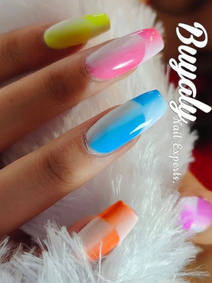 A vibrant ombre French manicure. This design features a different bright color on each nail, blended seamlessly for a fun and eye-catching rainbow effect.