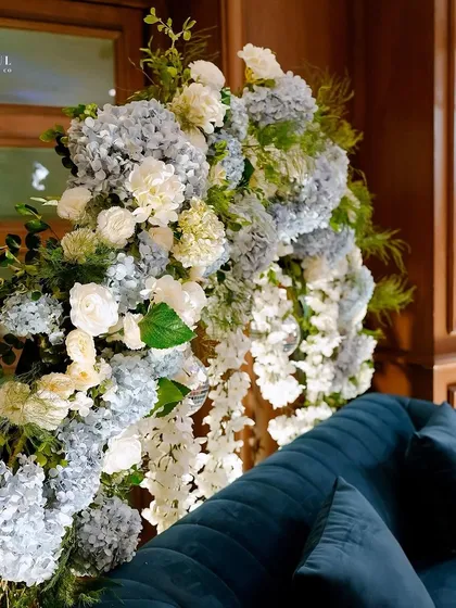 Another view of the blue and white floral arrangement for the Sangeet. The deep blue velvet couch adds a touch of luxury and contrasts beautifully with the soft, airy flowers.