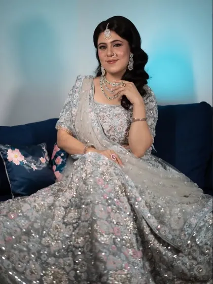 For this reception look, I created a full-glam style with a glittering silver lehenga. The hair is styled in soft, side-swept waves, paired with a smokey eye and a flawless base.