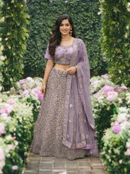 A full view of the lavender lehenga in a garden setting, showing how the color and embroidery stand out beautifully in natural light.