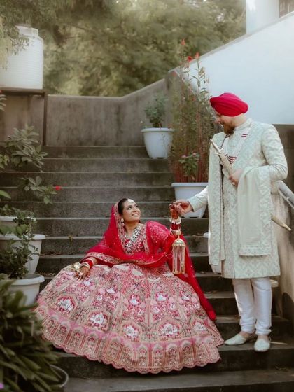A playful and romantic shot of the couple on a staircase, the groom lovingly holding the bride's kaleere.