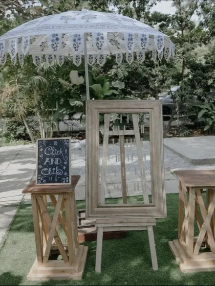 We love adding personal touches like this rustic photo-op corner. A vintage wooden frame on an easel, a lace parasol, and a charming chalkboard sign create a dedicated spot for guests to capture memories.