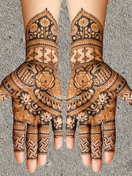 A symmetrical floral design with a large rose as the central element, surrounded by intricate patterns.