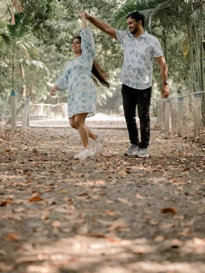 A playful moment of dancing in a rustic, wooded area. This fun, action-filled shot captures the couple's joyful energy and the beauty of the natural surroundings.