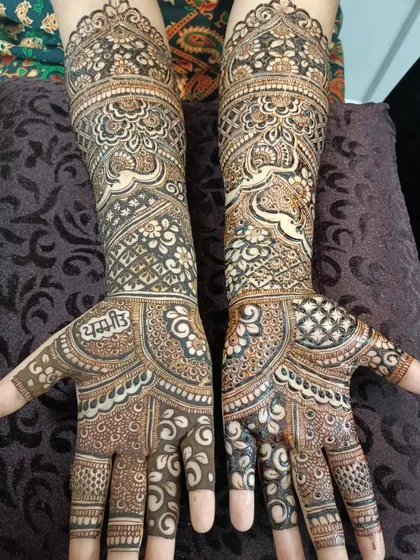 A full view of a bridal design that includes the groom's name, 'Yash', hidden within the intricate patterns on the palm.