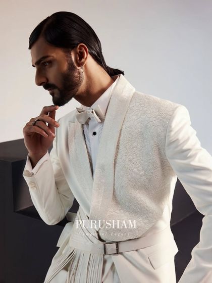 A profile view of the white belted suit. I believe in combining classic tailoring with striking accessories to craft a style that is both timeless and contemporary.