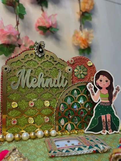 A detailed shot of the glittery green backdrop and personalized "Mehendi" cutout on our custom platter. The mirror work and pearl details add a touch of sparkle and elegance.