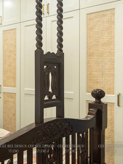 A restored heritage four-poster bed in a room with modern rattan-paneled wardrobes.