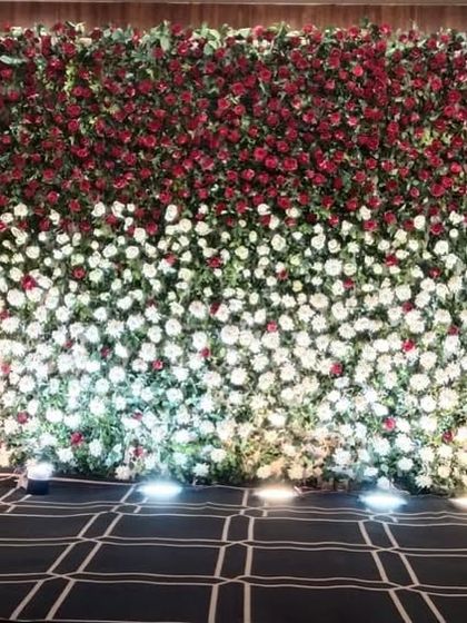 A full flower wall makes for a breathtaking stage backdrop. Here, we used a two-tone design with red and white flowers to create a simple yet dramatic and elegant setting for the couple.