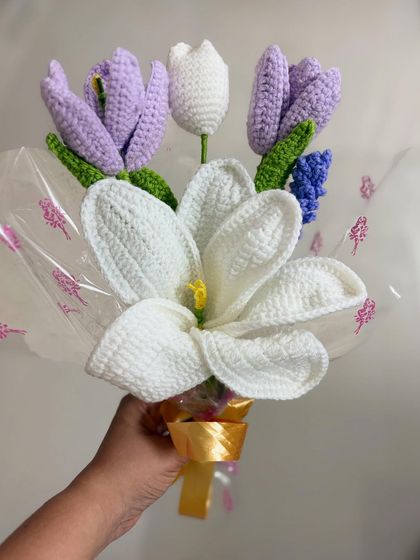 A close-up of the lily and tulip bouquet, showcasing the detailed stitch work on the petals and the delicate yellow stamen inside the lily.