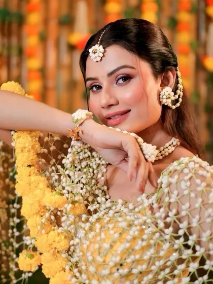 A beautiful portrait from the Haldi look recreation. The makeup is kept soft and glowing to let the intricate floral jewelry and the bride's happiness be the focus.