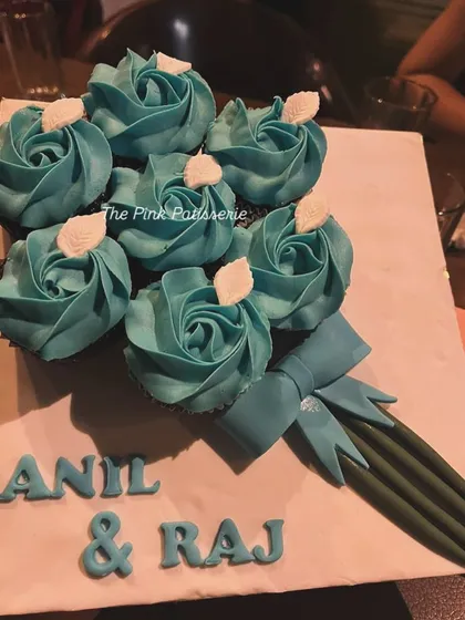 A creative cupcake bouquet with blue frosted roses, arranged to look like a bunch of flowers for Anil & Raj.