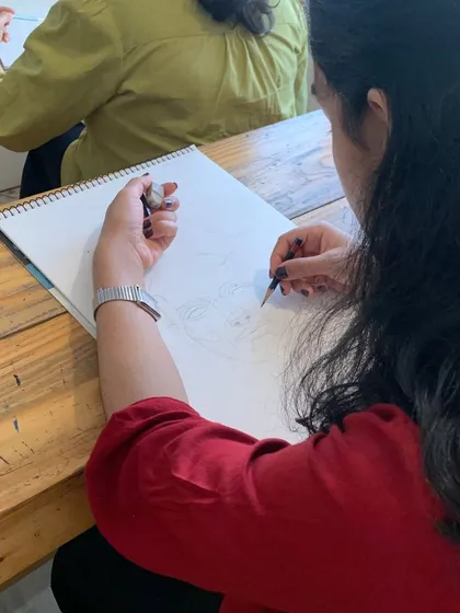 A student works on a charcoal portrait, demonstrating the skills learned in our specialized courses.
