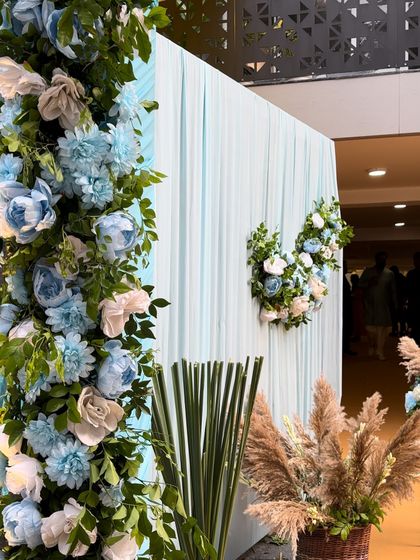For this Sai Sandhya, we created a serene backdrop with flowing light blue drapes and a large floral arch made of blue and white roses. The design evokes a sense of peace and devotion.