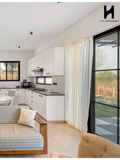 A view of the sleek, white modular kitchen in the French villa, seamlessly integrated with the living and dining areas.