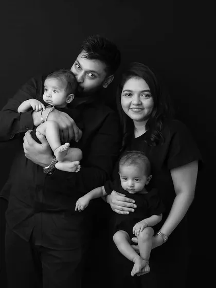 A candid family moment, with dad giving one of the twins a kiss. These unscripted interactions are what make family photos with twins so special.