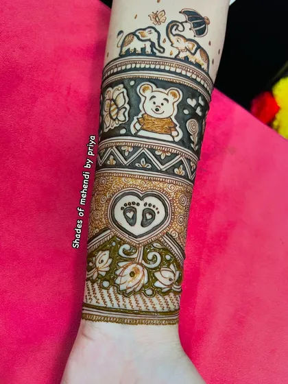A close-up of the forearm part of a baby shower design. It features a cute teddy bear, playful elephants, and a heart with baby footprints.