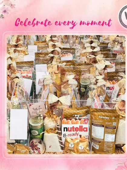 A large acrylic box filled with numerous gift items, including Nutella B-ready bars and Farmley snacks. This image shows how I can create abundant, impressive hampers for celebrating major milestones or for large-scale corporate gifting.