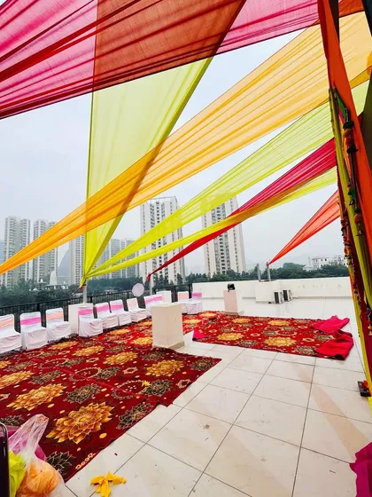 Transforming a rooftop into a party space with colorful drapes. This is an effective way to create a festive atmosphere for a Haldi or any other celebration in an open area.