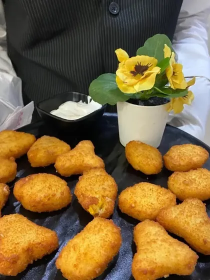 Our Cheese Corn Nuggets are a favorite among guests of all ages. These crispy, golden bites are filled with a creamy mixture of cheese and corn, served hot with a dipping sauce.