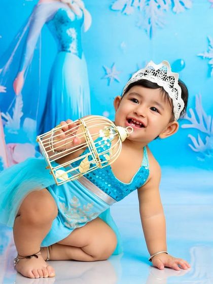 A happy smile from our little ice princess. She's having a wonderful time playing with the props in her magical, snowy kingdom.